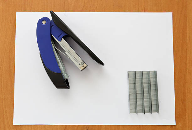 istock Blue stapler and staples with paper on the table 521987518