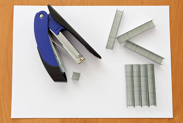 istock Blue stapler and staples with paper on the table 521987540