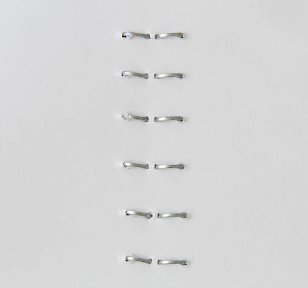 Staples in a stapled paper, macro view Staples in a stapled paper, macro view staple stock pictures, royalty-free photos & images