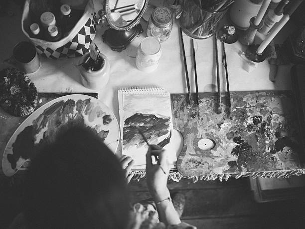 istock Artist painting on paper on a messy studio table 521989002
