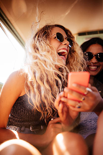 hipster chica observando a teléfono inteligente con amigos carretera viaje - nostalgia emoción fotos fotografías e imágenes de stock
