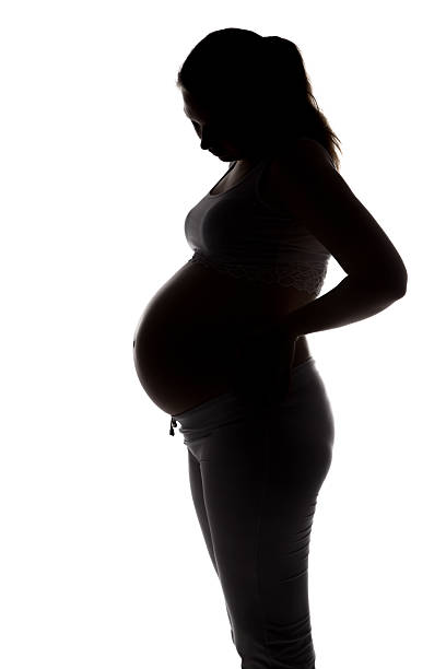 istock Silhouette of future mother looking at belly 521990456