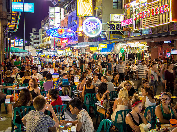 Khao San Road in Bangkok, Thailand Bangkok, Thailand - August 10, 2014: Street shops set up in Khao San Road in Bangkok, Thailand and a crowd of people walking and browsing through the kiosks. Various neon signages can be seen in the background. khao san road stock pictures, royalty-free photos & images