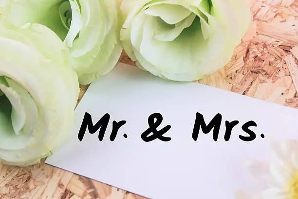 word mr&mrs on card flower wooden background