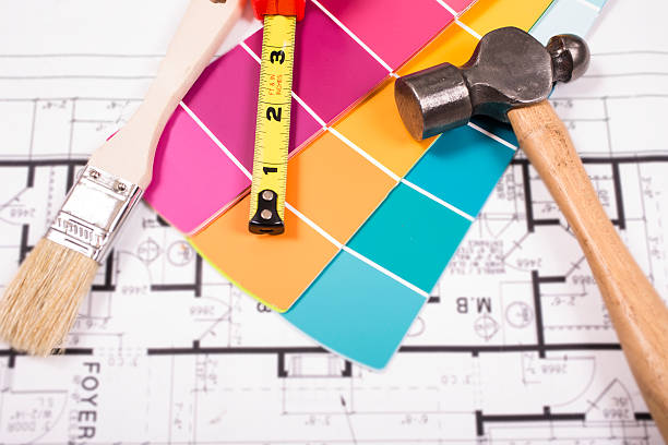 Painting, DIY construction tools lie on home blueprints, plans.