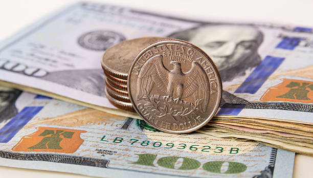 US Currency with one quarter coins stock photo