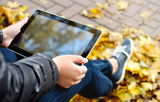 Usando tableta en otoño - foto de stock