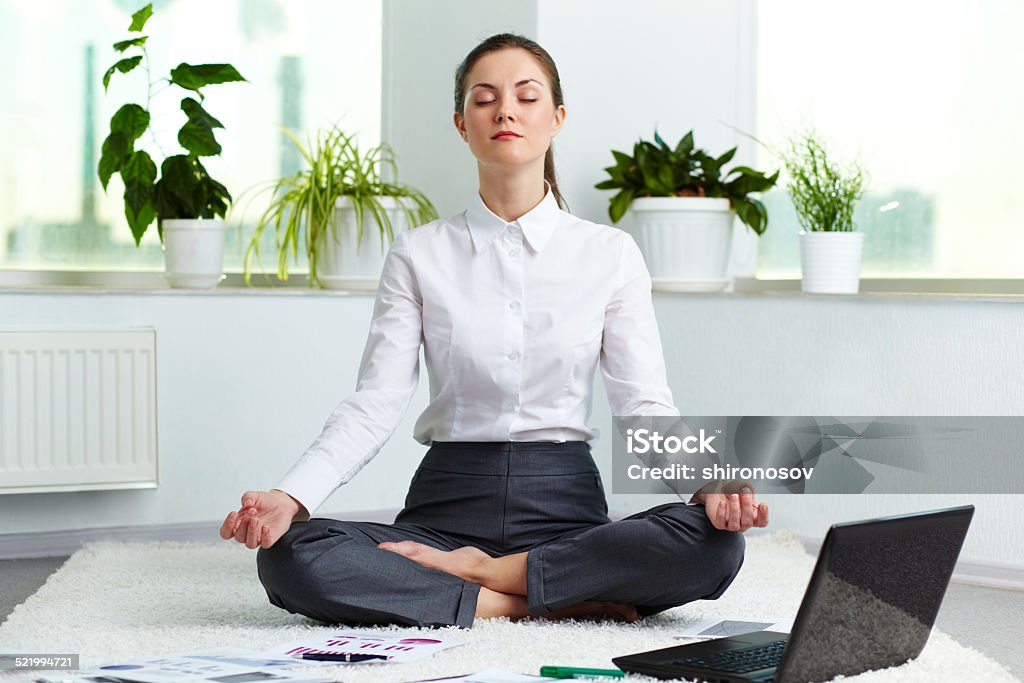 Relaxation Portrait of attractive white collar worker meditating in office Meditating Stock Photo