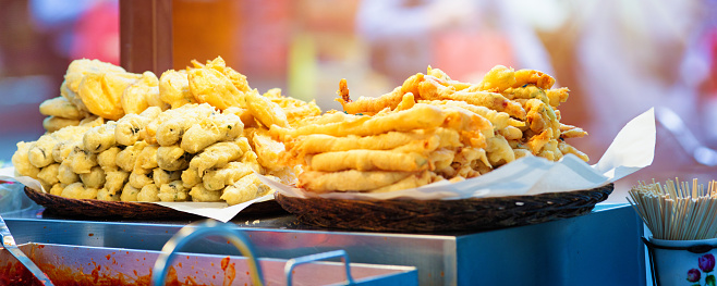 Fresh fried fast food for sale on Korean Seoul street, in a panoramic format.