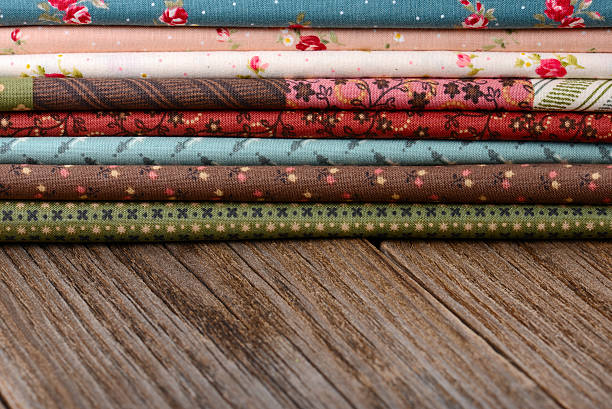 istock heap of cloth fabrics on wooden table 521998649