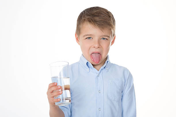 disgusted young child boy refusing to drink water sour face stock pictures, royalty-free photos & images
