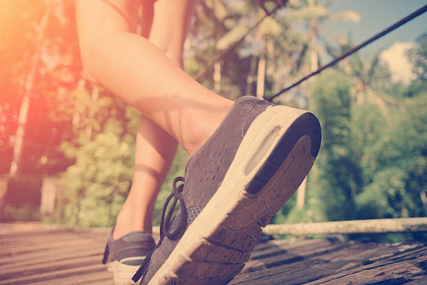 istock Woman's legs walking across hanging bridge 522000068