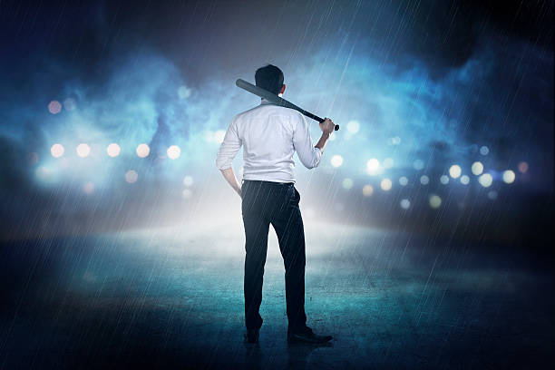 Man in white shirt holding baseball bat