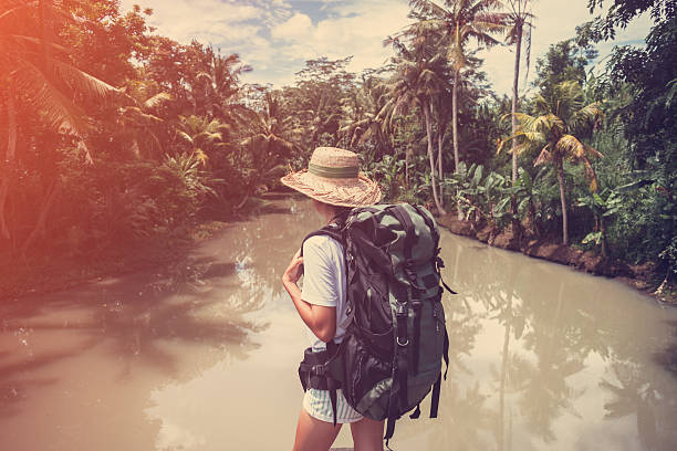 istock Fit woman with backpack standing near big tropical 522002098