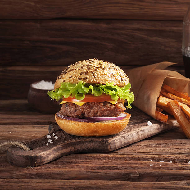 istock Burger with fries on a dark wooden background 522002676