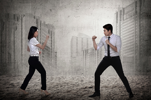 Business man and woman fighting. Working competition concept