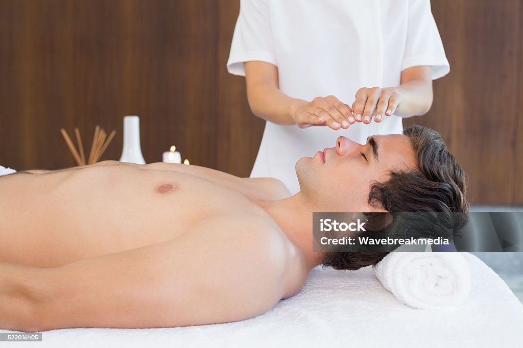 Man receiving treatment at spa center Side view of a handsome young man receiving treatment at spa center 20-24 Years Stock Photo