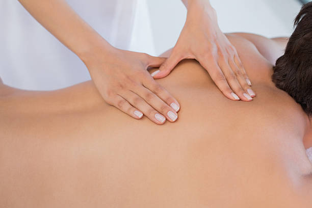 Close up mid section of a man receiving back massage at spa center