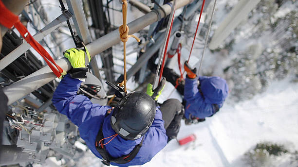 istock Two telecommunication manual high worker engineers repairing antenna 522021125