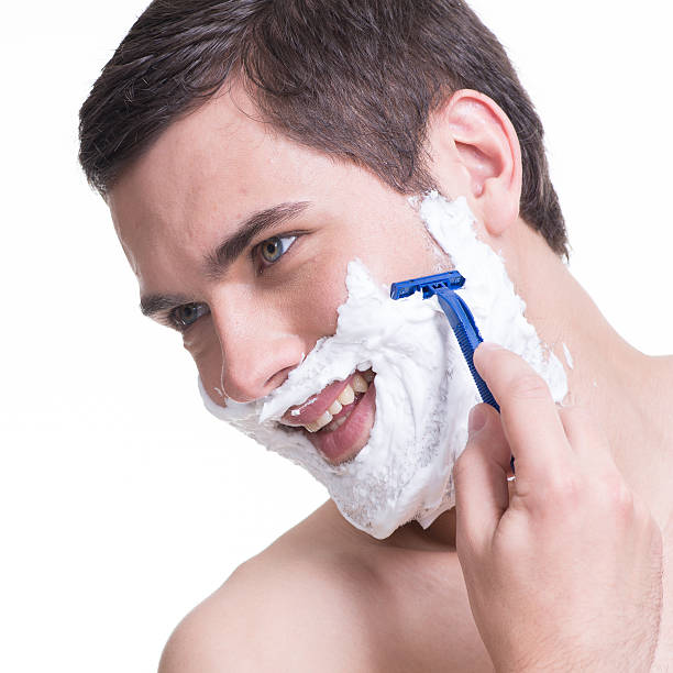 istock young man shaving the  beard with the razor 522033123