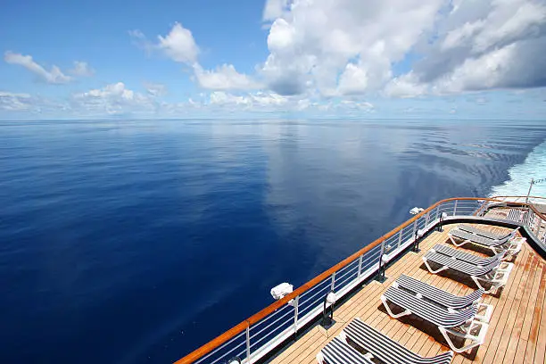 Photo of Cruise ship sails across a beautiful calm ocean.