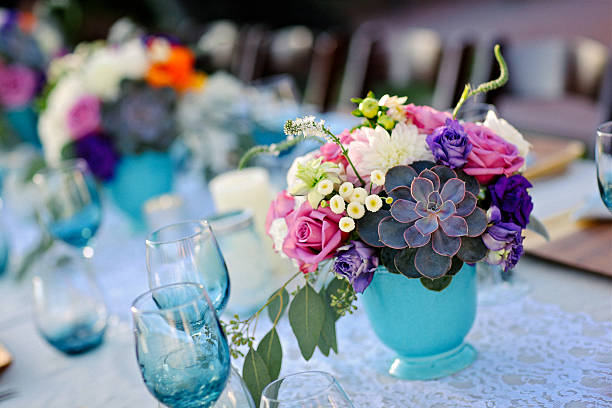 Table set for outdoor party with pink and white daisies, shot with shallow focus on front place setting.