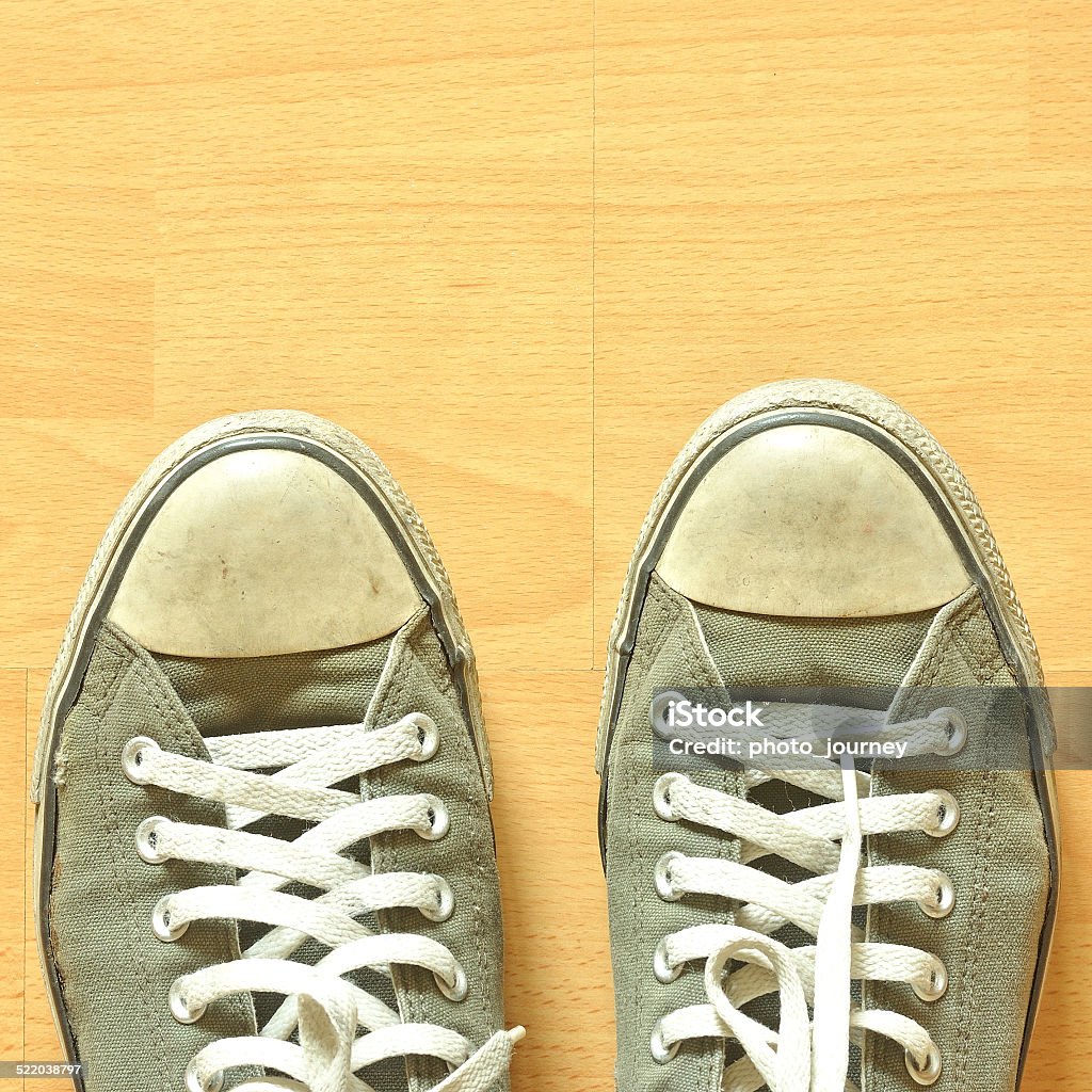 Old sneakers A pair of sneakers on wooden surface  Adult Stock Photo