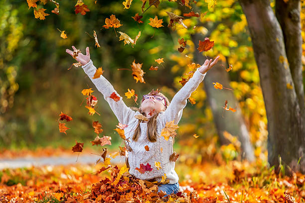 istock Girl playfully thrown away over his head colored maple leaves 522038943