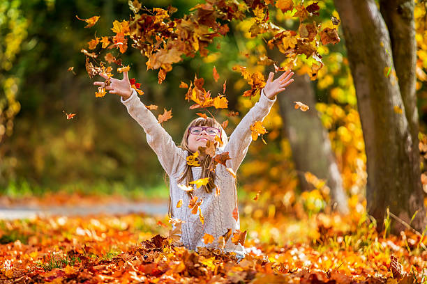 istock Girl playfully thrown away over his head colored maple leaves 522038945