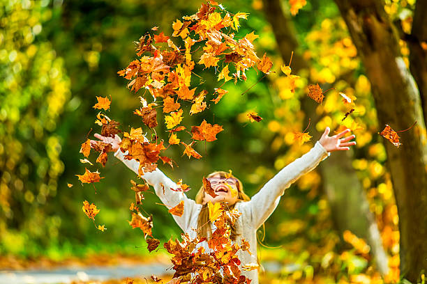 istock Girl playfully thrown away over his head colored maple leaves 522051203