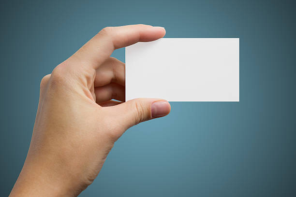 istock Hand holds a white business card on a blue background 522052265