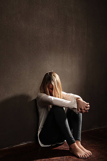 istock sad teen head down setting in dark room 522052311