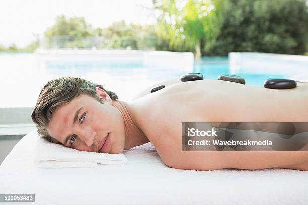 Handsome Man Receiving Stone Massage At Spa Center Stock Photo - Download Image Now - 20-29 Years, 25-29 Years, Adult