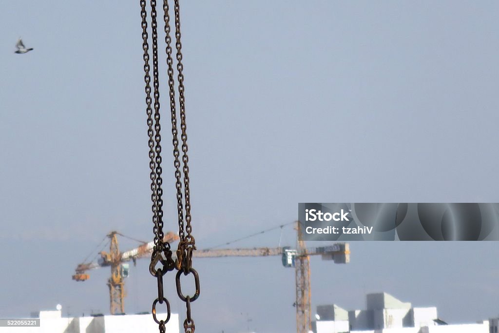 Cranes on a construction site A close-up of massive chains Apartment Stock Photo