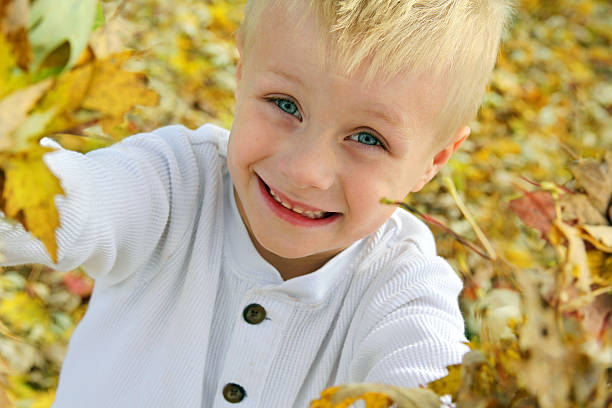 istock Happy Young Child Playing Outside with Fallen Autumn Leaves 522074525