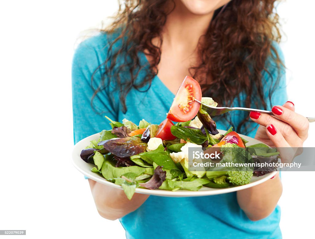 Mujer comiendo una ensalada sobre fondo blanco - Foto de stock de Agarrar libre de derechos