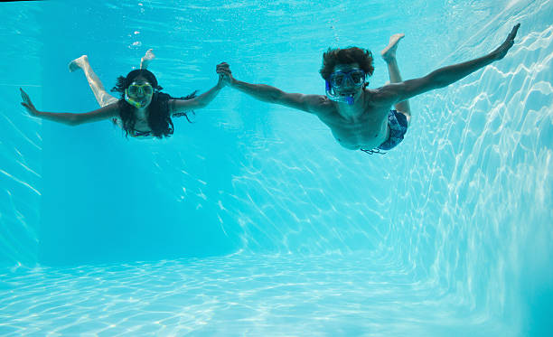 istock Couple wearing snorkels in swimming pool 522079695