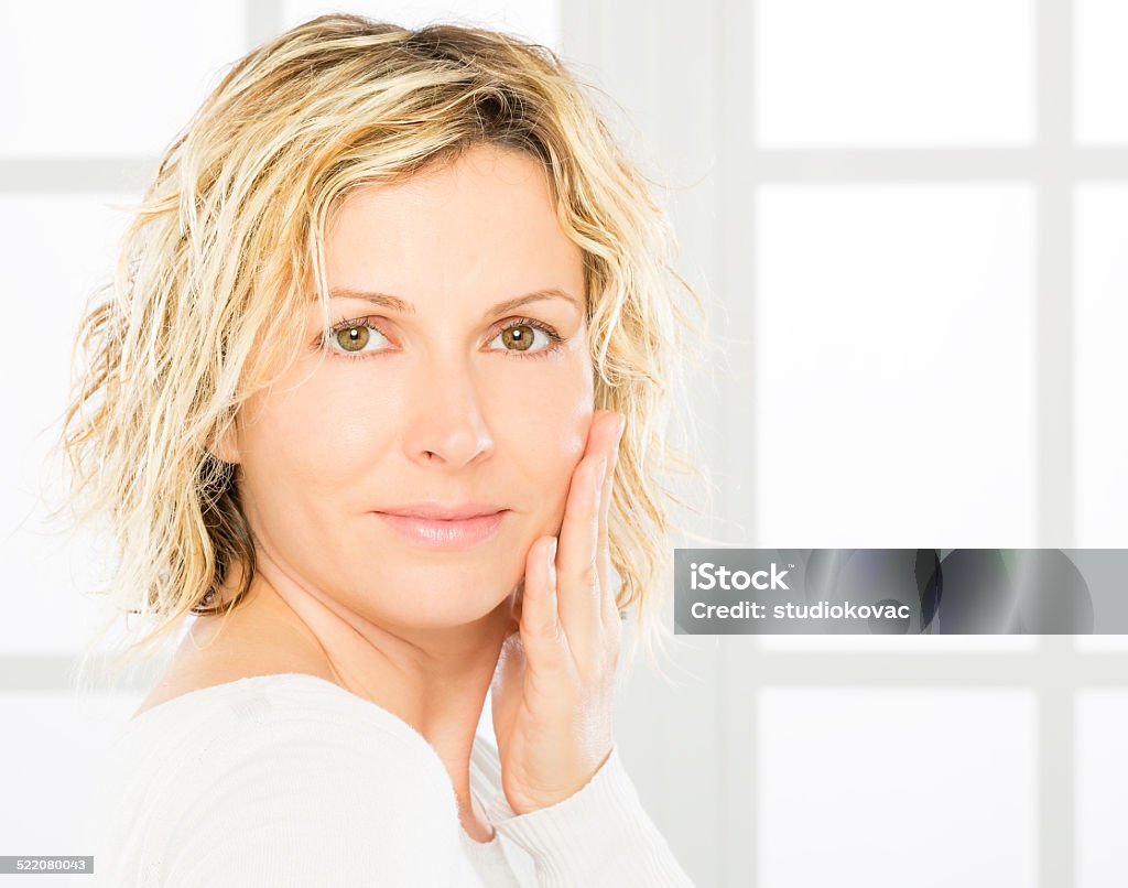 Woman, middle age and skin care. Mature woman with head on face looking to camera.  Beauty Stock Photo