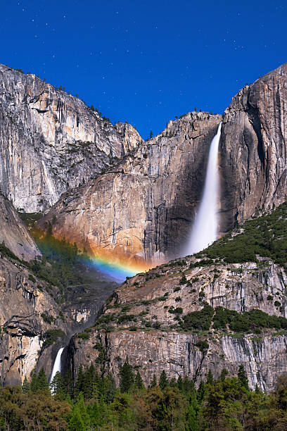 Midnight Moonbow Rainbow created by waterfall mist under the moon.  At Yosemite National Park. yosemite falls stock pictures, royalty-free photos & images