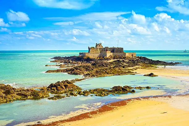 Photo of Saint Malo Fort National and rocks, low tide. Brittany, France.