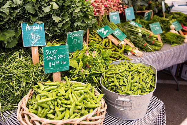 Organic Snap Peas, Arugula and Spinach in baskets and bins at Californian Farmer Market.