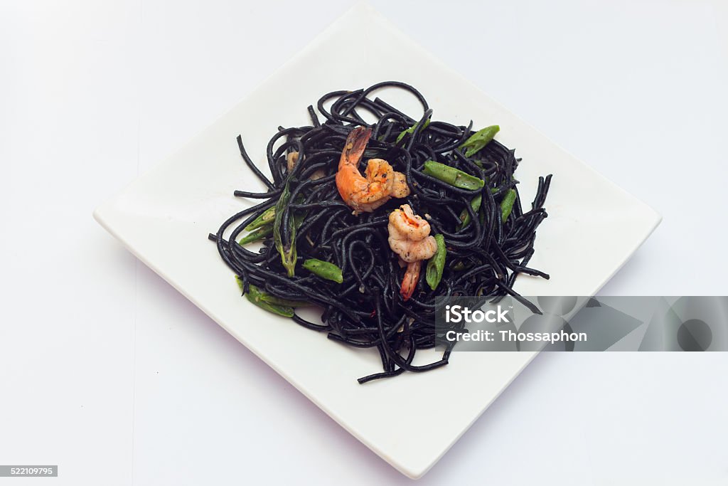 Black tagliatelle with shrumps, mussel and squid Black tagliatelle (pasta made with cuttlefish ink) with shrumps, mussel and squid Arugula Stock Photo