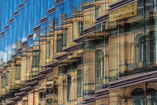 old building facade, new building exterior - old building facade reflection in modern building glass facade