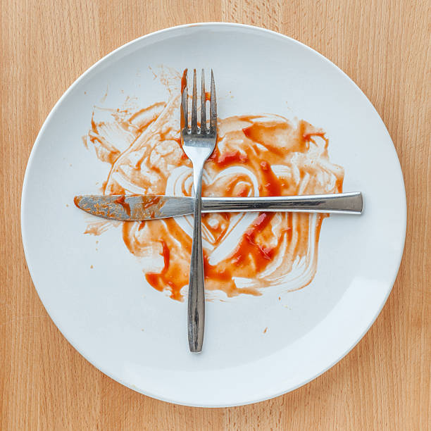 istock Knife and fork crossed in finish plate smeared with ketchup, 522123836