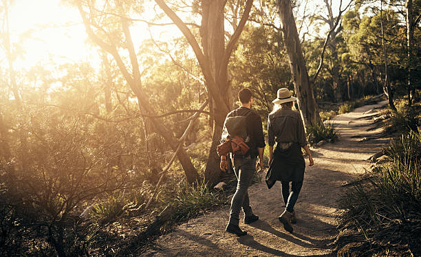 Spending a weekend in the wilderness Shot of a couple going for a walk on a nature trail common couple men outdoors stock pictures, royalty-free photos & images