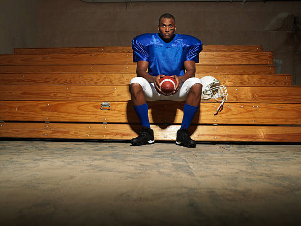 istock American Football Player With Ball On Bench 522127331