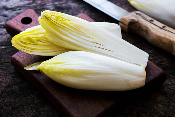 achicoria una ensalada fresca sobre tabla de madera rústica. - achicoria fotografías e imágenes de stock