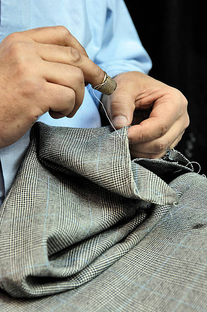 istock Tailor's hands sewing on businessman clothes 522129840