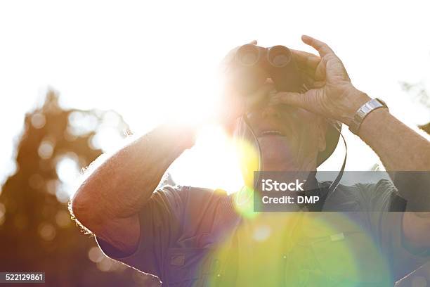 Mature Man Looking Through Binoculars Stock Photo - Download Image Now - Senior Adult, Binoculars, Bird Watching