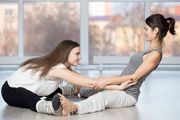 sitzen mühelos pose mit partner - the splits flexibility yoga teenage girls stock-fotos und bilder